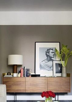 a living room filled with furniture and a painting on the wall over a coffee table