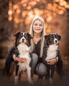 a woman kneeling down with two dogs in front of her and an orange boket background