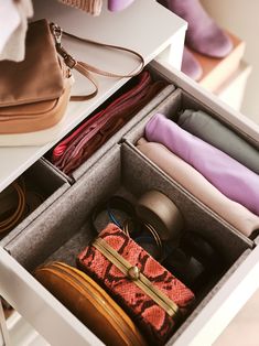 an open suitcase sitting on top of a table next to a handbag and purse