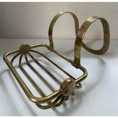 a metal rack with two rings on it's sides and an object in the shape of a heart