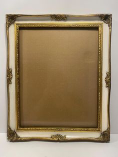 an ornate gold and white frame on the wall