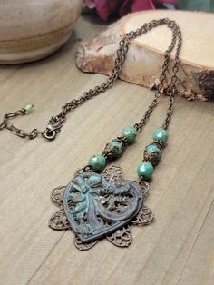 Experience the timeless beauty of our Antiqued Brass Filigree Heart Assemblage Necklace. With vintage romantic Victorian filigree and a stunning patina heart, this necklace is perfect for any occasion. The Czech glass beaded chain adds an extra touch of elegance, making it the perfect gift for someone special. *Antiqued brass filigree *Antiqued brass heart with patina and rhinestone *Faceted Czech glass beads *Antiqued brass chain *Lobster clasp closure *Chain measures 18" Pendant is 3" *One of a Kind *Created in studio - Wilmington, NC Copper Heart Pendant For Jewelry Making, Vintage Double Heart Charm Necklaces, Valentine's Day Heart Pendant Necklaces, Metal Heart Pendant Necklace With Soldered Details, Vintage Bronze Heart Pendant Necklace, Vintage Heart Necklaces With Vintage Charm, Vintage Bronze Heart Necklace, Vintage Heart-shaped Necklace With Vintage Charm, Heart Shaped Vintage Necklace With Charm