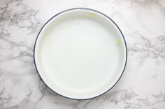 a bowl filled with milk sitting on top of a marble counter