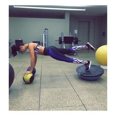 a woman is doing push ups on a ball