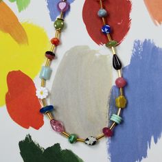 The Mariposa Beaded Necklace is fun personified. This multicolored, beaded necklace is sure to make you smile. This necklace is handmade using an assortment of beads including Czech glass and gemstone beads on a single strand of colorful loveliness! While each bead might have a different color, consistency, pattern, texture and shape, they are all separated by a cylindrical golden bead. This allows for you to really be able to see the unique beauty of the necklace and still have unity in the des Fun Beaded Necklaces With Tiny Beads For Gifts, Fun Beaded Necklace With Tiny Beads For Gift, Whimsical Adjustable Beaded Necklace With Colorful Beads, Multicolor Czech Glass Necklaces With Oval Beads, Multicolor Czech Glass Necklace With Oval Beads, Multicolor Czech Glass Oval Bead Necklace, Whimsical Adjustable Beaded Necklaces With Heart Beads, Fun Beaded Necklaces As Gift, Multicolor Czech Glass Gemstone Beads