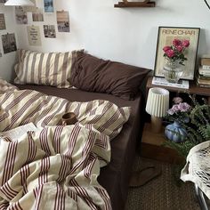 a bed sitting in a bedroom next to a table with flowers on top of it