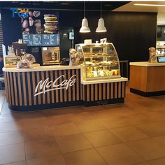 the inside of a bakery with lots of counter space and lights hanging from the ceiling