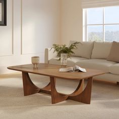 a living room with a couch, coffee table and vase on the carpeted floor