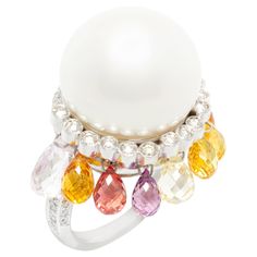 The South Sea pearl and diamond cocktail ring features a splendid pearl of 17mm diameter. The pearl is untreated. It displays a fine nacre and its natural color and luster have not been enhanced in any way. The pearl is perched on a crown of round diamonds of top quality (F/G-VVS) for a total weight of 1.20 carats. The crown suspends eight briolette cut sapphires of different pastel colors for a total of approximately 8 carats. The splendid ring is one-of-a-kind. It was handmade in Italy in our Fancy Pink Diamond Ring, Cocktail Ring Designs, Sapphire Cocktail Ring, Diamond Bracelet Design, Pink Diamond Ring, Genie Bottle, Vintage Cocktail Ring, Diamond Cocktail Ring, White Gold Sapphire