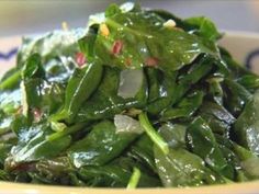 a bowl filled with green vegetables on top of a table