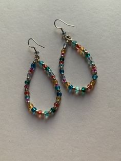 Assorted multicolor glass beads in these teardrop shape earrings. The wire is made of non-tarnish Silver. Adds a pop of color to any outfit. Handmade with love. Personalization available: can add more of a certain color, less, etc. Czech Glass Teardrop Earrings With Ear Wire, Nickel-free Czech Glass Teardrop Earrings, Handmade Czech Glass Teardrop Earrings, Colorful Teardrop Jewelry, Multicolor Teardrop Beads For Jewelry Making, Multicolor Teardrop Jewelry For Jewelry Making, Nickel-free Rainbow Teardrop Earrings, Czech Glass Teardrop Dangle Earrings With Ear Wire, Multicolor Wire Wrapped Beaded Earrings