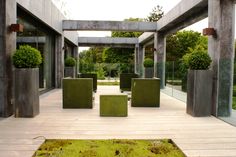 an outdoor area with several planters and benches on the ground, surrounded by concrete pillars