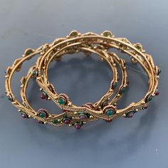 Very well ~ handmade ~ Vintage ~ gold plated ~ open-back faux gemstones stack-able bangle lot of 4 ~ Beautiful details all around . Unsigned from India Dates late 20th century . Materials : gold plated metal Faux gemstones enamel Measurements : Each bangle is approx 7 inches in wearable length x 1/4 inches max width ~ Inner diameter is 2 3/8 inches . Condition : Overall bracelet is in good vintage condition ~ No missing or replaced stone ~ some metal discoloration /darkening seen ~ Clasps are in Adjustable Jeweled Bangle Jewelry, Bohemian Hand Set Metal Bracelets, Metal Bracelets With Stone Setting, Bohemian Hand Set Round Bangle, Metal Bangle Bracelets With Stones, Adjustable Gold Bangle With Jewels, Bohemian Stackable Gold Bangle, Bohemian Stackable Bangle Jewelry, Gold Bohemian Stackable Bangle