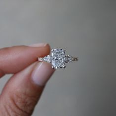 a person is holding a diamond ring in their left hand and the other side has two diamonds on it