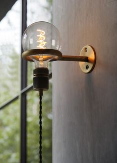 a light that is on the side of a wall next to a glass door and window