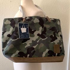 a green and brown camouflage bag sitting on top of a white mannequin