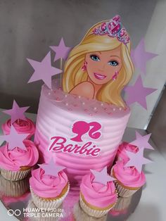 a barbie birthday cake with pink frosting and cupcakes