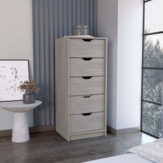 a bedroom scene with focus on the chest of drawers and an art piece in the background