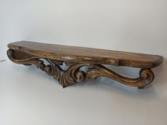 an old wooden bench with carved designs on the top and bottom, against a white background