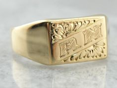 "Ever so sweet, this vintage signet ring has a lovely floral motif! The engraving was so well done that we've left it as is, with \"RN\" monogramed on the top in hope that someone loves it as much as we do! This could either be representitive of someone's initials, or even a piece for a practicing or retired nurse!  Please note that this signet ring has its original monogram, unfortunately, this piece cannot be altered without affecting the quality of the piece, please feel free to contact us to help you find your perfect signet ring in your style and budget!  Metal: 18K Yellow Gold  Top Measurements: 9 x 13 mm, Rectangle  Monogram: \"RN\" Initials  Ring Size: 9 Marks: \"18Ct DEAK 750\" Stamped on the inside band  SKU #: MH08YD-P Each piece has been identified and graded by a Graduate Gemo Rectangular 14k Stamped Signet Ring Collectible, Vintage Gold Initial Ring Stamped 14k, Formal Yellow Gold Stamped Engraved Ring, Vintage Stamped Initial Ring For Anniversary, Collectible Yellow Gold Signet Ring With Initials, Vintage Initial Ring For Anniversary, Vintage Yellow Gold Signet Ring With Hallmarks, Oval Stamped 14k Gold Signet Ring, Vintage White Gold Signet Ring Stamped 14k