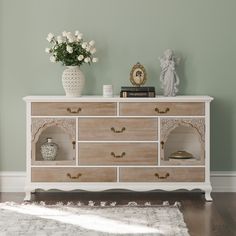 a white and wood dresser with flowers on top