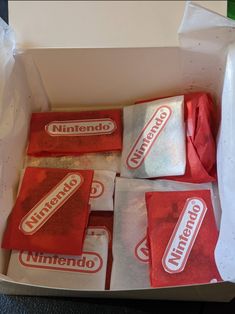 nine unopened nintendo wii games in a white box with red and silver wrappers