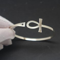 "Silver Ankh Bracelet is handmade with its own uniqueness. It can be bought as a gift for any occasion like birthday gift, wedding gift, travel gift, souvenir and etc. If you need rose gold plating or yellow gold plating, please contact us, we will advice you on the additional fees applicable. You can choose the stone color but it is subject to availability. Please convo us. Base Material: Sterling Silver Size / Depth: 19mm (Approximately) Stone: Black CZ Bangle wrist size: 6'' - 7.5''. Adjustab Symbolic Handmade Bracelets For Friendship, Symbolic Handmade Friendship Bracelets, Handmade Silver Promise Bracelets, Adjustable Bangle Bracelet For Promise, Handmade Adjustable Spiritual Bangle, Adjustable Symbolic Bangle, Adjustable Symbolic Bangle Bracelet, Symbolic Adjustable Promise Jewelry, Handmade Symbolic Bangle Bracelets