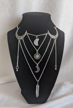 This gorgeous necklace looks like a layered piece, but is actually all in one! No hassle of putting on/taking off multiple necklaces, this piece gives off a witchy, magical look. The necklace features moons, stars, a sun, and a crystal moon and stick arranged in a uniquely magical way! Perfect for special occasions or to add a little magic to your everyday Choose between silver and bronze Choose between an amethyst moon and stick or a clear quartz moon and stick The shortest chain measures at 16 Mystical Silver Necklace For Party, Silver Festival Choker With Moon Charm, Bohemian Silver Crystal Clavicle Chain Necklace, Bohemian Silver Crystal Necklace With Clavicle Chain, Celestial Silver Necklace For Party, Silver Celestial Necklace For Party, Festival Moon Phase Choker Necklace, Silver Celestial Party Necklace, Mystical Metal Necklaces For Parties