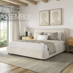 a bedroom with white walls and wood floors, two framed pictures on the wall above the bed