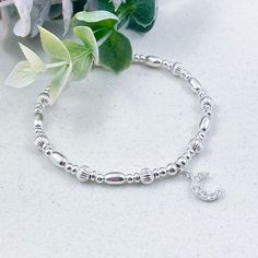 This beautiful sterling silver celestial bracelet that embodies both beauty and symbolism, features a stunning, Cubic Zirconia crescent moon charm that represents intuition and feminine energy  This bracelet allows you to carry the symbolism and energy of the moon with you wherever you go. Whether you're seeking a meaningful gift for a loved one or a personal talisman for yourself, this enchanting accessory serves as a timeless expression of cosmic connection and spiritual significance  The eclectic mix of high-quality sterling silver beads are stung onto strong, professional grade jewellers' elastic, meaning there are no fiddly clasps to deal with, simply roll the bracelet over your hand and onto your wrist Sterling silver is a precious metal known for its durability, luster and resistanc Silver Beaded Bracelets With Moon Charm As Gift, Celestial Sterling Silver Bracelets, Sterling Silver Bracelet With Moon Charm, Sterling Silver Bracelets With Moon Charm, Silver Spiritual Bracelets With Moon Phase, Celestial Silver Charm Bracelet, Sterling Silver Moon Phase Bracelet As Gift, Sterling Silver Moon Phase Bracelet For Gift, Sterling Silver Celestial Bracelet With Moon Charm