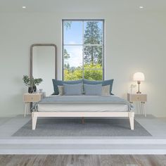 a bedroom with a bed, mirror and two nightstands in front of a large window