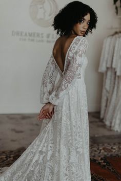 the back of a woman's wedding dress, with long sleeves and open shoulders