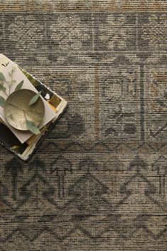 an old rug with some plates on top of it and a plant in the middle