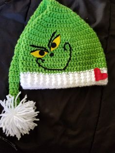 a crocheted hat with the grin face on it