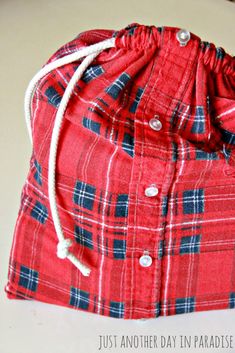 a red plaid drawstring bag sitting on top of a table