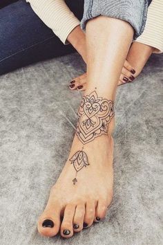 a woman's foot with tattoos on it