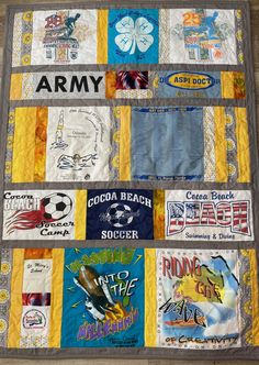 a quilted wall hanging on the side of a wooden floor covered in patches and stickers