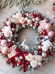 a christmas wreath on the floor with ornaments around it