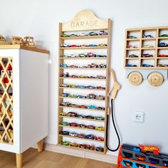 toy cars are lined up on the wall next to a shelf with a sign that says garage