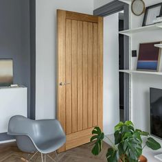 a living room with a chair, television and bookshelf