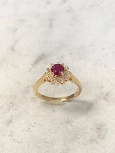 14kt Yellow Gold Lady's Diamond and Ruby Classic Halo Ring consisting of a 5mm round genuine Ruby with deep red color and tone 1/2ct approx. total weight prong set surrounded by accent diamonds .12ct total weight all prong set in solid heavy mounting in finger size 5 3/4. This item would Retail for $1,985.00 Red Cluster Ring With Brilliant Cut, Red Cluster Ring With Brilliant Round Cut, 14k Gold Red Cluster Ring With Brilliant Cut, 14k Gold Ruby Ring With Halo Setting, Classic Red Cluster Ring, Red Brilliant Cut Birthstone Ring In 14k Gold, Fine Jewelry Red Diamond Ring Stamped 14k, Red Cluster Ring With Prong Setting, Round Cut, Red Brilliant Cut 14k Gold Birthstone Ring