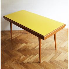 a yellow table sitting on top of a wooden floor