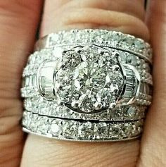 a woman's hand with two wedding rings on top of her finger and the other ring