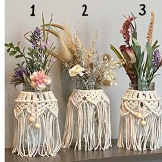 three vases with flowers and plants in them