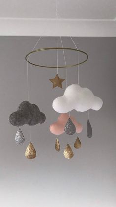 a mobile with clouds, rain drops and stars hanging from the ceiling in a child's room