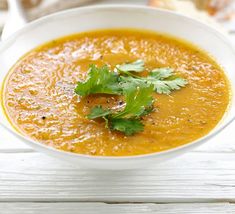 a white bowl filled with soup and garnished with cilantro