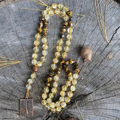 "So maybe prayer beads aren't your thing. I get it. Not everyone is into spirituality, gratitude practices, or mindfulness. Totally fine. I've got something for you too. 🤗 This beautiful, beaded necklace features the following: 8mm natural, polished, round Citrine 8mm star cut Yellow Tiger's Eye 10mm Brown Sandalwood connector bead Each bead is individually hand-knotted on durable, gold nylon thread and completed with a Tree of Life pewter pendant with an antique copper finish. 💛🤎 Each bead has been individually hand-knotted by me.✨ 💛 Citrine is called the \"stone of manifestation\". It is said to attract prosperity, wealth, and success. It imparts joy and cheerfulness on the wearer.  🤎 Yellow Tiger's Eye is known as the \"stone of courage\". It is said to attract good luck while incr Elegant Citrine Gemstone Bead Necklaces, Elegant Citrine Gemstone Beads Necklace, Citrine Beaded Necklace, Luxury Citrine Gemstone Beads Jewelry, Tigers Eye Crystal Necklace, Citrine Beads, Pewter Pendant, Tiger Eye Beads, Tigers Eye