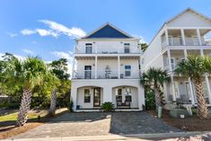 two white houses with balconies and palm trees