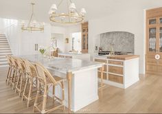 a large kitchen with marble counter tops and wooden chairs