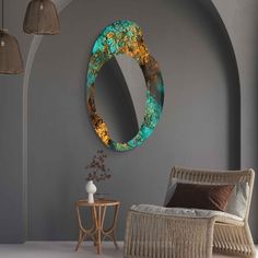 a round mirror hanging on the wall next to a wicker chair and side table